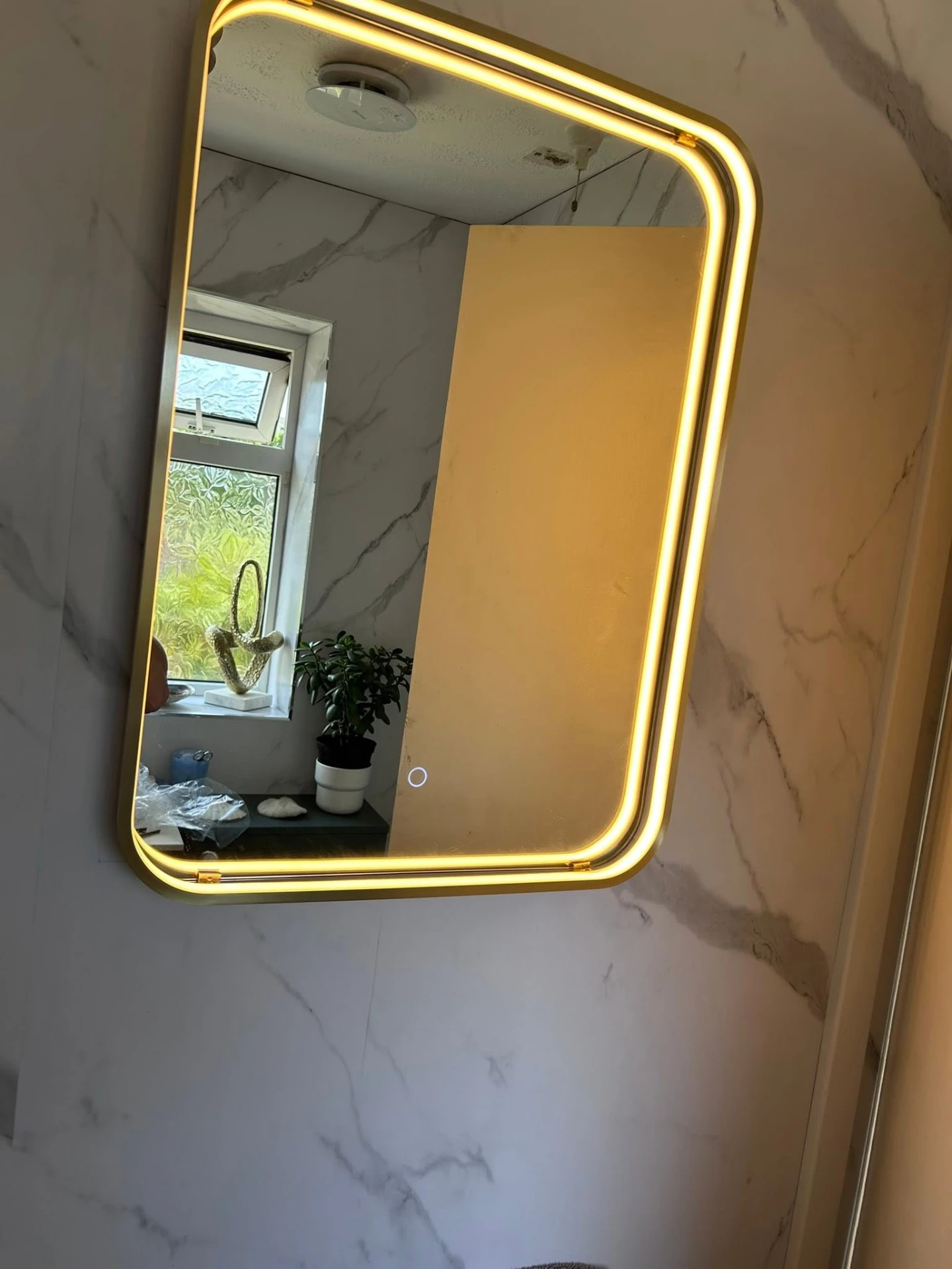 Illuminated LED bathroom mirror installed on a marble-effect tiled wall, electrical work by Morlec Electrical