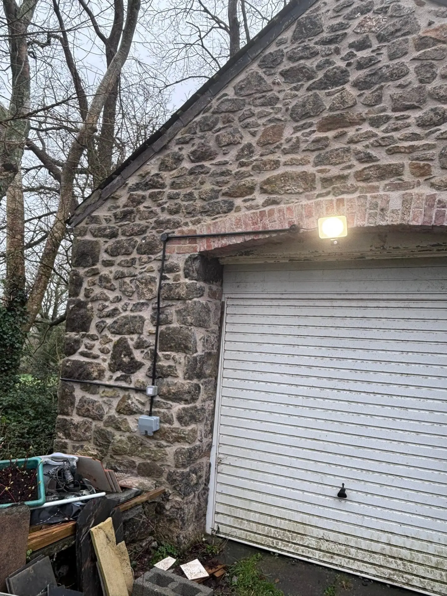 Exterior floodlight and weatherproof electrical containment installed on a stone building in Pembrokeshire